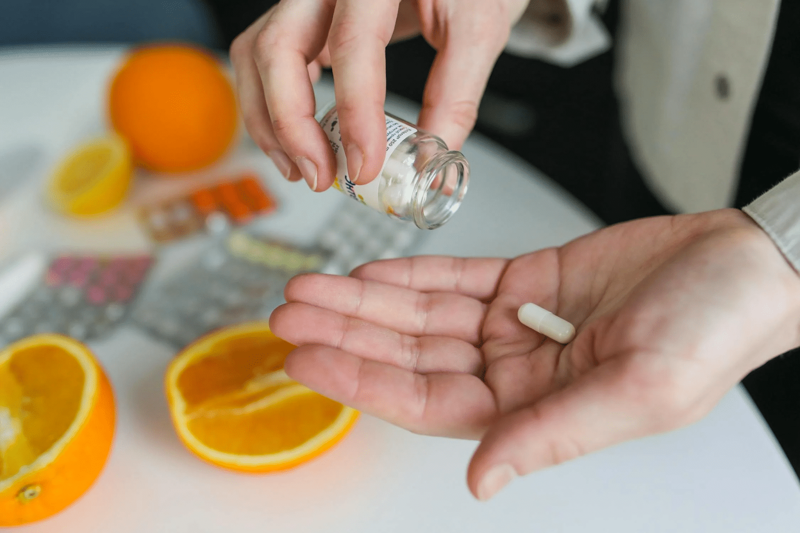 person taking vitamin c supplement pill