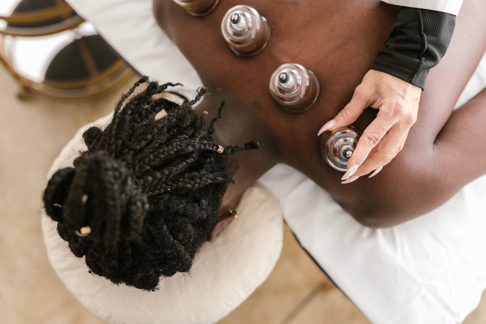 woman receives cupping therapy on her back from professional therapist